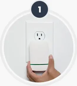 A hand pressing the plug-in unit into a wall outlet